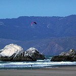 The beautiful Ocean Beach with people paragliding